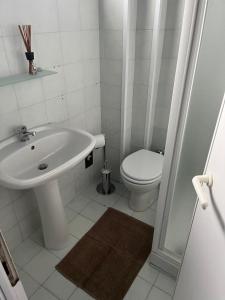 ein weißes Bad mit einem Waschbecken und einem WC in der Unterkunft Appartamento Fronte Mare in Civitanova Marche