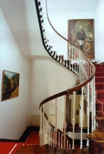 a spiral staircase in a house with a picture on the wall at Pazo Almuzara in Boborás