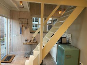 eine Treppe in einer Küche mit einem Tisch und einem Schreibtisch in der Unterkunft ‘t Bakhuis in Oostelbeers