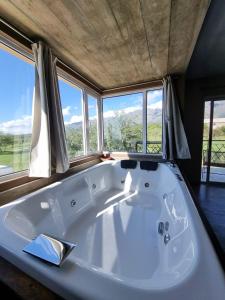 a large white bath tub in a room with windows at SOLSALI Cabaña moderna in San Javier