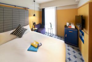 um quarto de hotel com uma grande cama branca com duas almofadas em Hotel Resol Yokohama Sakuragicho em Yokohama