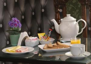 a table topped with plates of food and a tea pot at Hotel Casa Zañartu in Santiago