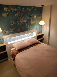 a bedroom with a bed with a floral wall at Superbe T2 avec grande terrasse en centre ville à 5 min à pieds des Arènes de Nîmes in Nîmes