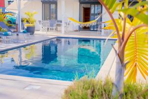 - une piscine dans une villa avec eau bleue dans l'établissement Ti Eden Villas a Saint-Francois, à Saint-François