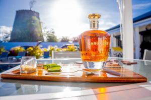 une bouteille de whisky et un verre sur une table dans l'établissement Ti Eden Villas a Saint-Francois, à Saint-François