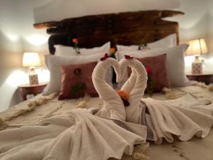 two swans made out of towels on a bed at Riad Malfa in Marrakesh