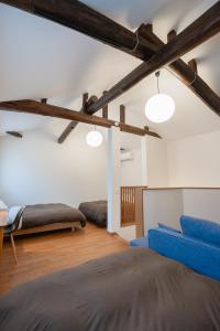 a bedroom with two beds and a blue couch at Coto in Miyazu