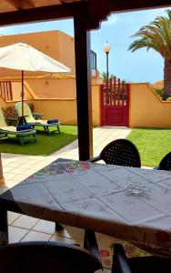 a table with chairs and an umbrella in a yard at GRANI MAR in Costa Calma