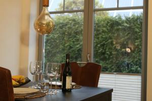 einen Tisch mit einer Flasche Wein und Gläsern darauf in der Unterkunft Appartement Delfi in Flensburg