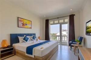 a bedroom with a large bed with a large window at Hoi An Aurora Riverside Hotel and Spa in Hoi An
