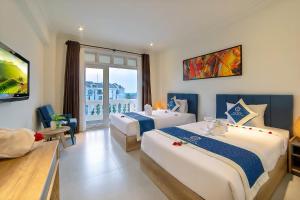 a hotel room with two beds and a balcony at Hoi An Aurora Riverside Hotel and Spa in Hoi An