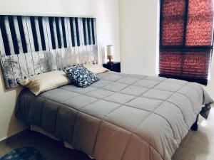 1 dormitorio con 1 cama grande y 2 almohadas en Depa en San Miguel de Allende Zirándaro con Piscina en San Miguel de Allende