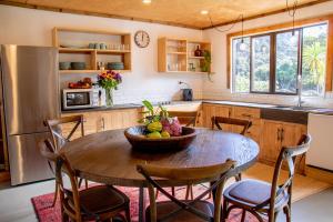 a kitchen with a table with a bowl of fruit on it at Parohe Island Retreat in Auckland