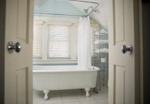 a white bath tub in a bathroom with a window at Dickson Street Bed & Breakfast in Fayetteville +45 photos