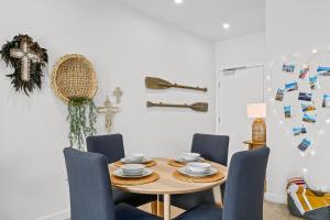 a dining room with a table and blue chairs at Hamptons By The Beach - Moana - C21 SouthCoast Holidays in Moana