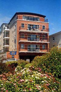 un edificio de apartamentos alto de ladrillo con balcones y árboles en Arus Grattan, en Galway