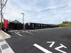 una lunga fila di vagoni ferroviari parcheggiati in un parcheggio di HOTEL R9 The Yard Minokamo a Minokamo