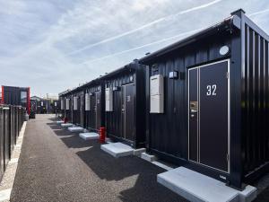 a row of black portable toilets are lined up at HOTEL R9 The Yard Minokamo in Minokamo