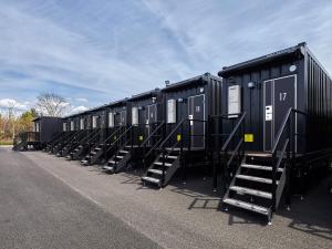 a row of black train cars parked in a row at HOTEL R9 The Yard Minokamo in Minokamo