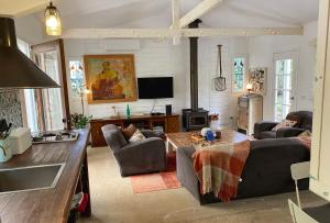 a living room with a couch and a tv at Birdsong Bellingen Farm in Thora