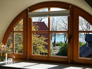 an arched window with a view of a yard at Reethaus mit Meerblick- In 30 Sekunden am Strand in Boltenhagen