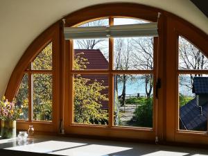 una ventana arqueada con vistas a un patio en Reethaus mit Meerblick- In 30 Sekunden am Strand en Boltenhagen