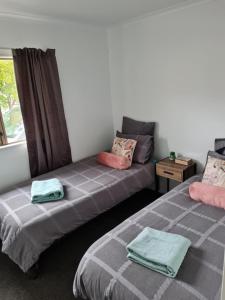 2 camas en una habitación con ventana en Cambria Hideaway en Nelson