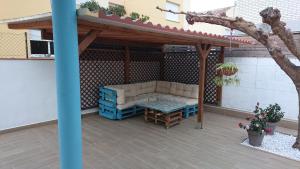 pérgola con sofá y mesa en el patio en Chalet playa, en Benicarló