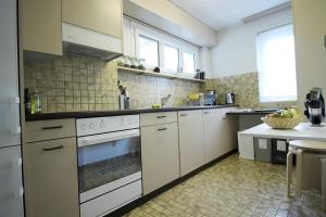 a large kitchen with white appliances and a table at Casa Schilling 25 Zimmer Mit Balkon Nahe Spital, Uni in St. Gallen
