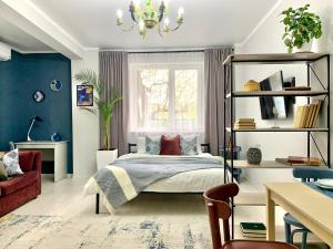 a bedroom with a bed and a window at Уникальная студия ЖЕРУЙЫК в стиле Этно в центре города in Almaty