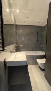 a bathroom with a sink and a toilet and a tub at MADOST APART MOKOTÓW 54 m2 Airport Chopin & Buisness in Warsaw