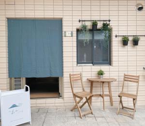 a patio with two chairs and a table and a window at 小島上island in Dongyin