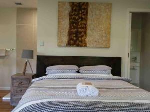 a bedroom with a large bed with two towels on it at Alaya Escape in Eudlo