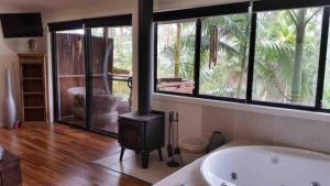 a bathroom with a bath tub and a wood stove at Alaya Escape in Eudlo