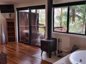 a bathroom with a wood stove next to a tub at Alaya Escape in Eudlo