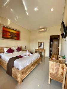 a bedroom with two beds and a flat screen tv at Wiki Bali in Ubud