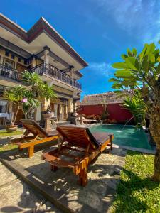 a resort with wooden benches and a swimming pool at Wiki Bali in Ubud