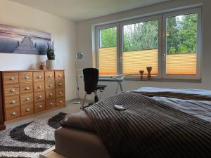 a bedroom with a bed and a desk and windows at Grüne Oase Am Mausauel in Nideggen