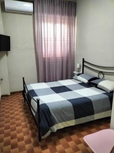 een slaapkamer met een zwart-wit bed en een raam bij Il sentiero del mare in Avola