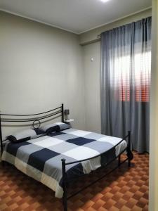 een slaapkamer met een zwart-wit bed en een raam bij Il sentiero del mare in Avola