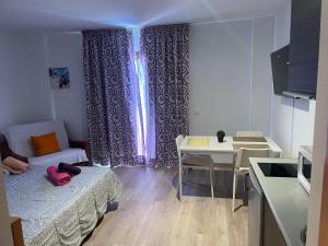 Habitación pequeña con cama y mesa. en apartamento playa privada, en Torre del Mar