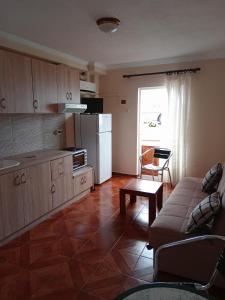 eine Küche und ein Wohnzimmer mit einem Sofa und einem Kühlschrank in der Unterkunft FAFALIOS Studios in Vrontádos