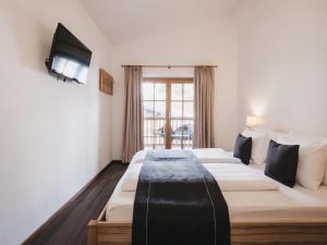 een hotelkamer met 2 bedden en een televisie bij Residence Kristall by VAYA in Saalbach Hinterglemm