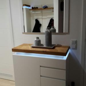 a bathroom with a counter with a sink and a mirror at Strand FeWo Rügen MoonLoft in Binz