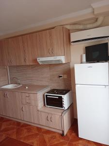 a small kitchen with a microwave and a refrigerator at FAFALIOS Studios in Vrontádos