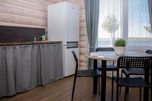 eine Küche mit Tisch, Stühlen und Kühlschrank in der Unterkunft Dzerkaļi in Cirma