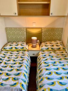 a bedroom with two beds and a nightstand between them at Ocean Edge Holiday Park Family holiday home with spectacular sea views in Heysham +19 photos
