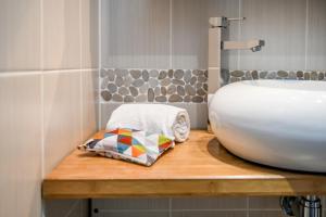 a bathroom with a white sink and a wooden counter at Logis Hotel de France in Mimizan-Plage +99 photos