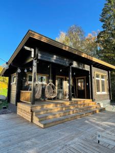 ein kleines Haus mit einer Veranda und einer Terrasse in der Unterkunft Vanha pappila Hetki Oy in Ähtäri