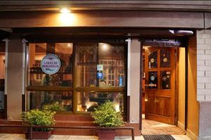 a front door of a restaurant with two plants in front at Magnolia Residency in Darjeeling